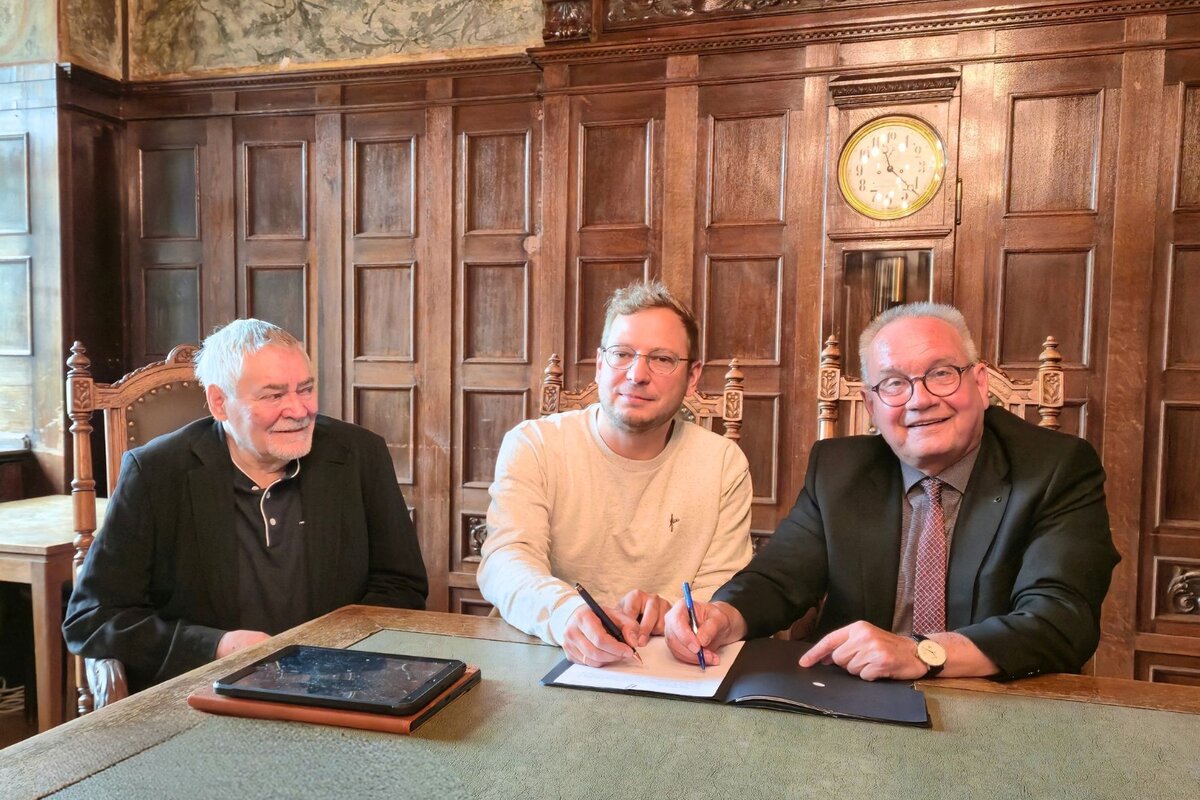 Benjamin Kant (Mitte) und Oberb&uuml;rgermeister Frank Ruch unterzeichnen den Vertrag zur Erstellung des Vermittlungskonzeptes f&uuml;r das Denkmal. Mit dabei ist Hans-J&uuml;rgen Kant (links).